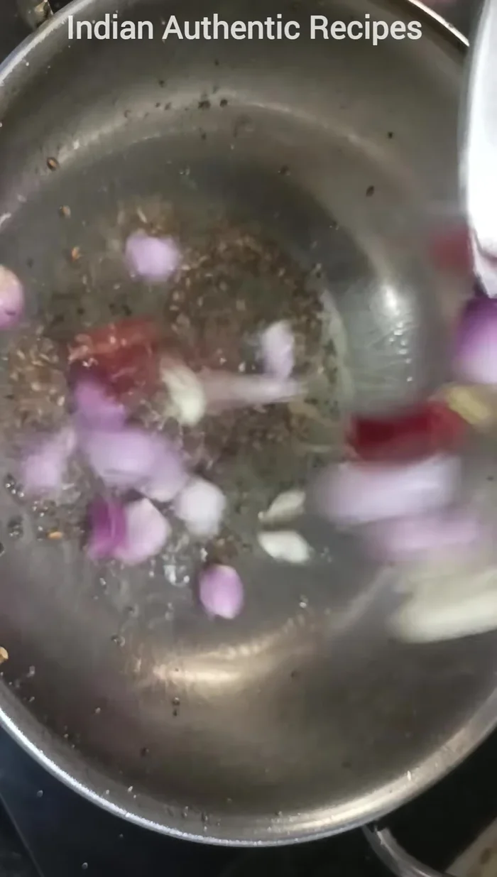 Add small onions, garlic, red chilies, and curry leaves. Fry for about two minutes.
