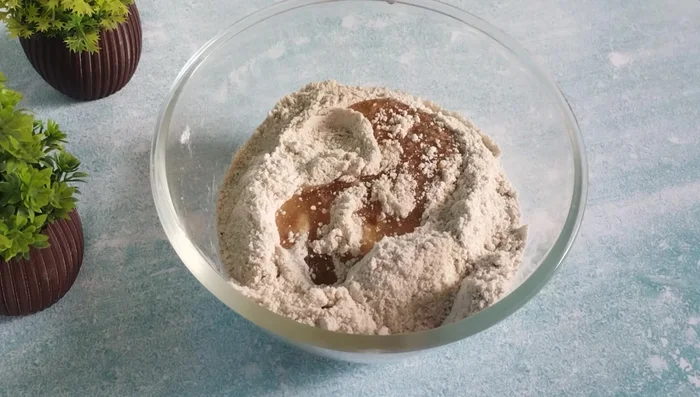 Add refined oil and mix well to create a crumbly texture. If needed, add more oil until the mixture binds.