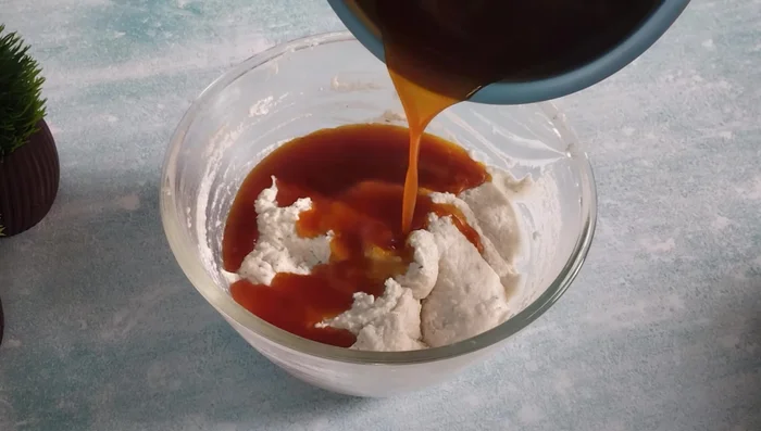 Add the melted jaggery to the dough, mixing gradually until a smooth, medium-thick batter is achieved. Don't make it too thick or too thin.