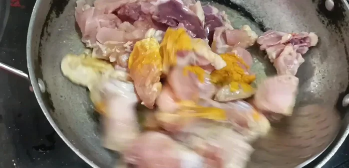 Add the fried chicken to the pan, add ½ tsp turmeric powder and ½ tsp salt, and fry for 2 minutes.