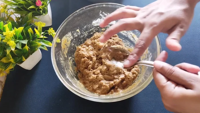 Beat the batter vigorously with your hands until it becomes fluffy and slightly less thick. If needed, add a spoonful or two more of water to adjust consistency.