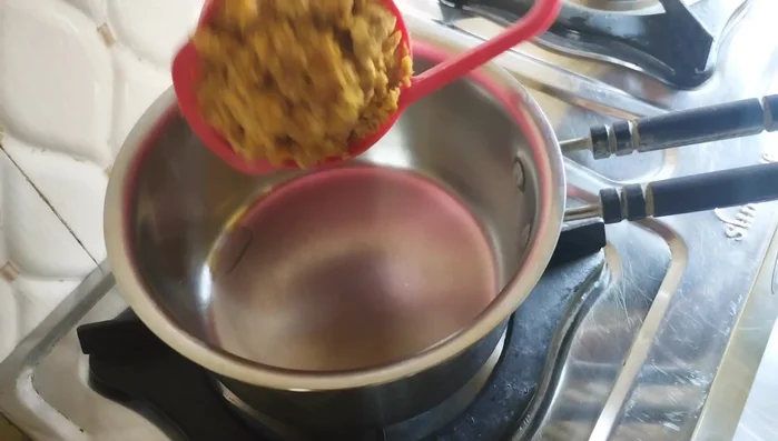 Put a saucepan on the gas and add half a cup of jaggery (cut into small pieces) and half a cup of water. Stir until the jaggery melts on low flame. You don't need a thick syrup, just melted jaggery.