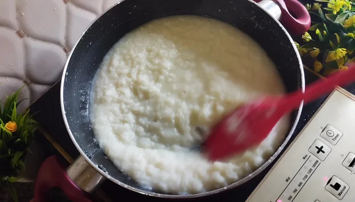 Cook on high flame until the mixture becomes very thick. Add 1/2 cup of milk powder (optional) gradually, mixing well to prevent lumps. Continue to stir.