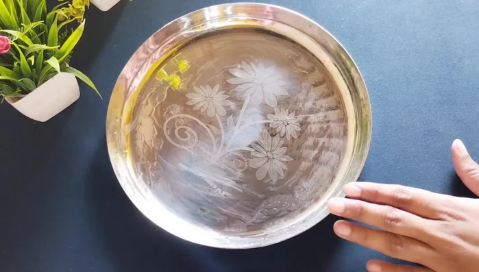 Grease a plate with ghee. Pour the mixture onto the plate and spread evenly using a spatula.
