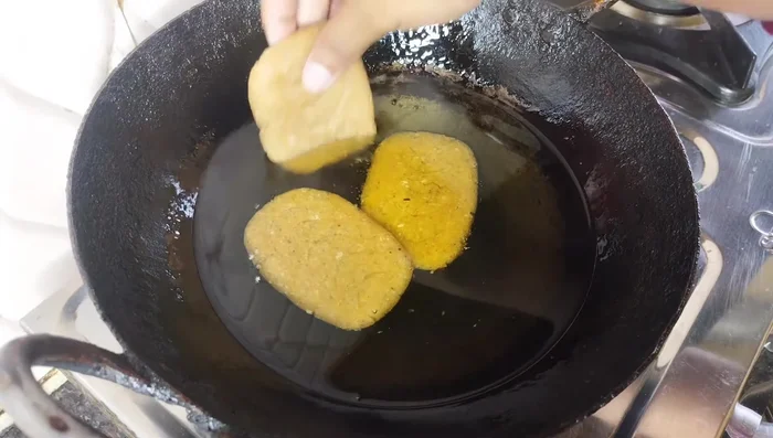 Heat oil in a pan over low heat. Fry the biscuits until golden brown, ensuring the oil is not too hot to prevent burning and rawness.