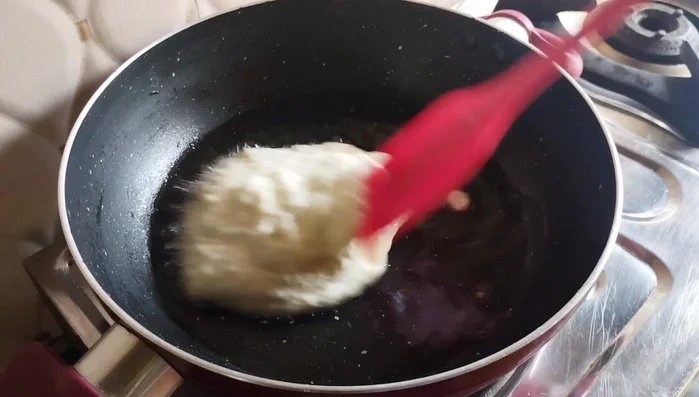 Add the soaked semolina to the heated ghee. Roast on low flame for 10-15 minutes, stirring continuously until the semolina grains separate and turn light brown.