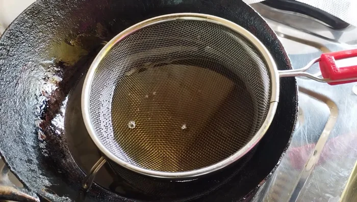 Heat oil in a pan. Using a sieve, fry the moong dal in batches over high heat until the foam subsides and the dal becomes crispy and golden brown. Avoid low heat frying to prevent oiliness.