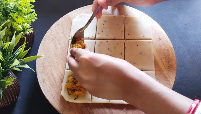 Fill each small square with potato masala and fold into a patty (483.36).