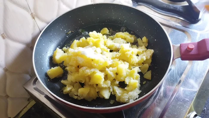 Add boiled and roughly broken potatoes, salt, turmeric powder, cumin seeds, and red chili powder. Mix well and fry for 4-5 minutes (58.359).