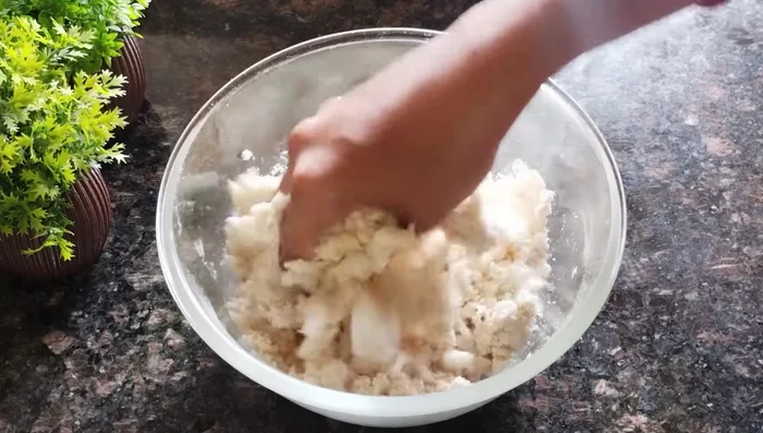 Gradually add water, kneading until a stiff, hard dough forms. Avoid adding too much water, as a soft dough will result in less crispy mathri.