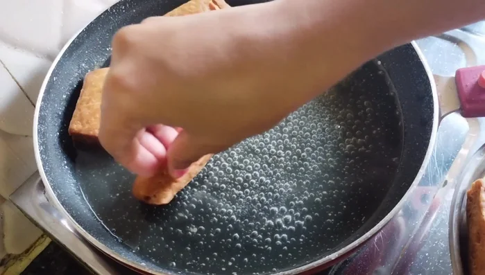 Add the fried Goja pieces to the hot syrup. Gently stir and let them soak for about half an hour.