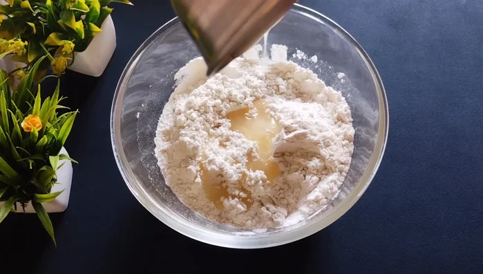 Add 2 tablespoons of melted ghee to the flour mixture and mix well. The better you mix, the crispier the Goja will be.