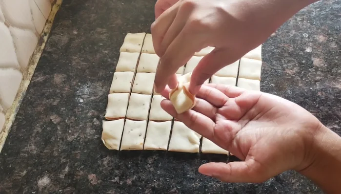 Take each square and pinch two opposite corners to create a flower shape. Repeat with remaining pieces.