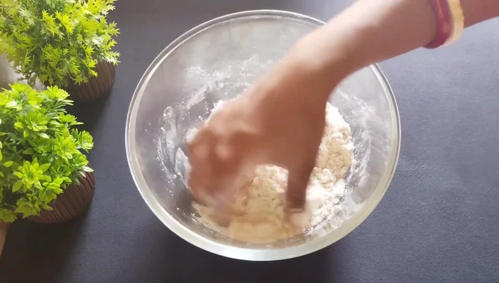 Gradually add water to form a stiff, not soft, dough. Rest the dough for 10-15 minutes.