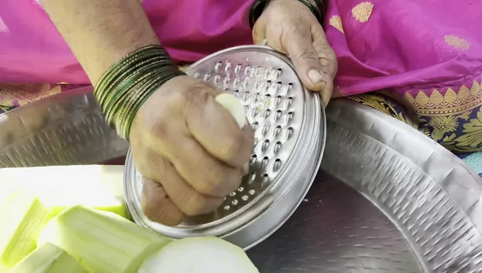 Grate the pumpkin. Don't grate for too long, as the color turns black quickly.