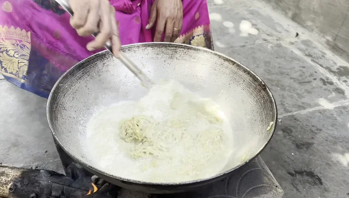 Add milk to the fried pumpkin and cook until it becomes a dough-like consistency.