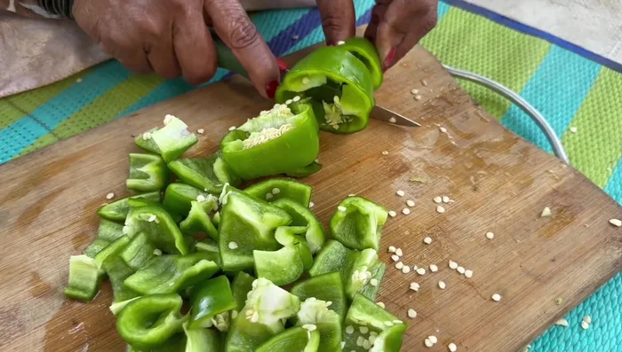Cut capsicum into three parts, then into square pieces.
