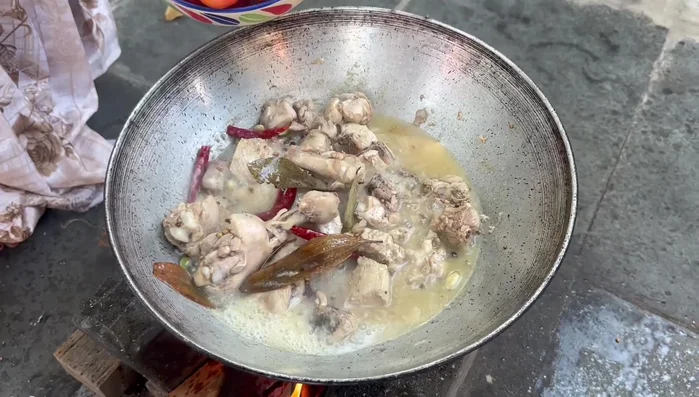 Add tomatoes to the steamed chicken. Once cooked, remove the tomato skins.