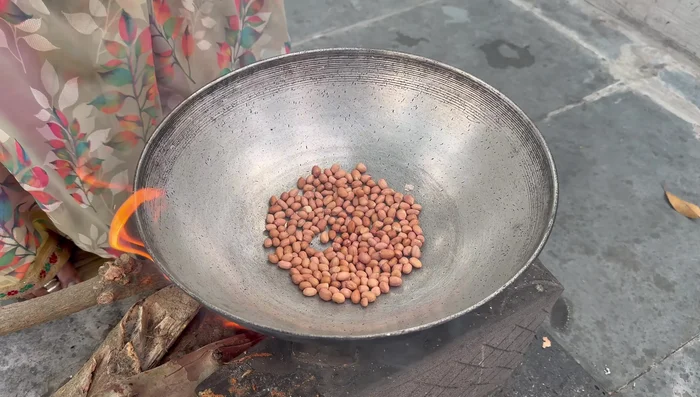 Roast peanuts in a pan until nicely browned. Remove and peel them.
