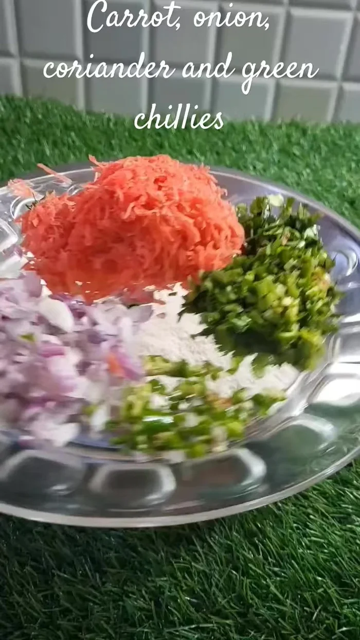 In a bowl, combine rice flour, onion, grated carrot, green chili, green coriander, dill greens, cumin, salt, and water to make a soft dough.