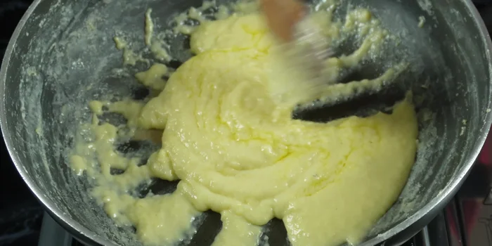 Continue to stir until the sugar dissolves completely and a thick paste forms. Stir in another teaspoon of ghee to prevent sticking.