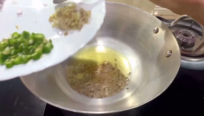 Heat oil and ghee in a pan. Add cumin seeds, chopped ginger, garlic, green chilies, and onions. Sauté until onions turn light golden brown.