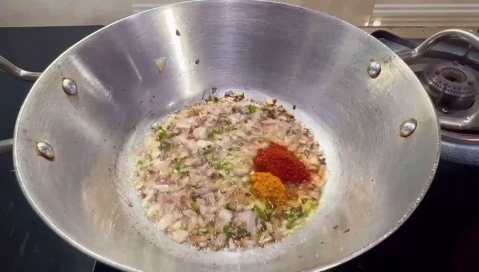 Add turmeric powder and red chili powder. Sauté briefly.