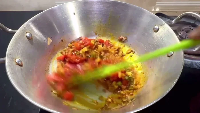 Add chopped tomatoes and cook until softened, stirring continuously.