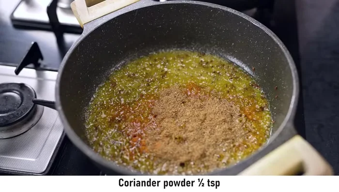 Add turmeric powder, coriander powder, cumin powder, and red chili powder to the tadka.
