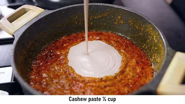 Once the curd mixture is cooked, add cashew paste (made from boiled cashews).