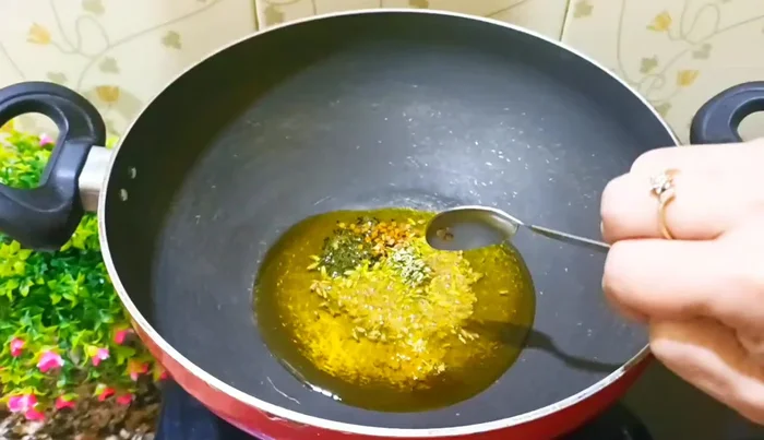 Add asafoetida, bay leaves, and dried red chilies. Stir well. Reduce the flame to low.