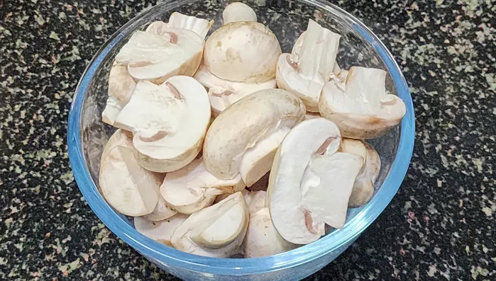Wash mushrooms thoroughly, add salt and turmeric. Cut them into pieces.