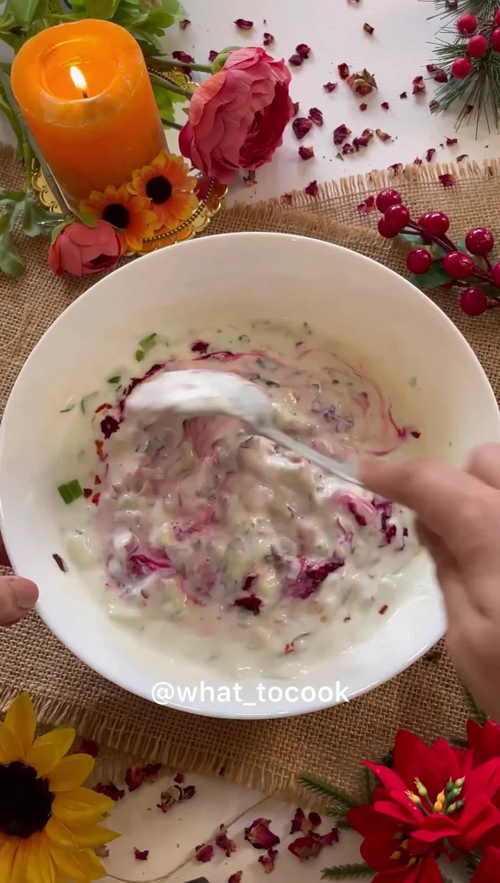 Add the grated beetroot to the raita and mix well until the color is evenly distributed.