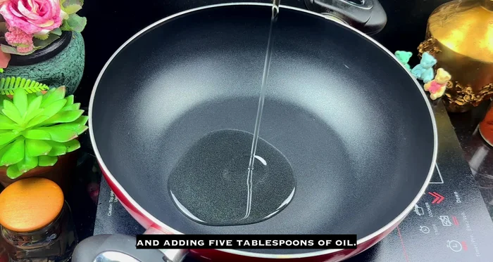 Heat 5 tbsps of oil in a wok. Let the oil heat well to release the aroma of the spices.