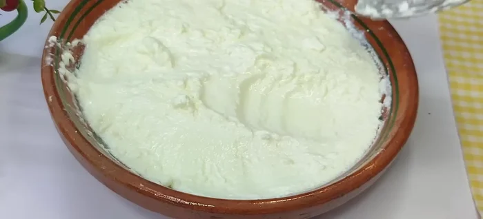 Once set, gently scoop out the thick cream (malai) from the top of the yogurt, which you will use for butter and ghee.