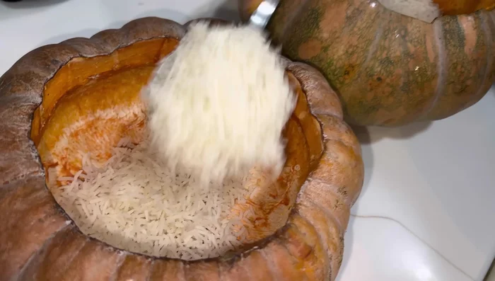 Layer the pumpkin biryani: Place a layer of rice in the pumpkin, followed by a layer of chicken curry (including chicken pieces, eggs, and potatoes), and then another layer of rice. Repeat layering.