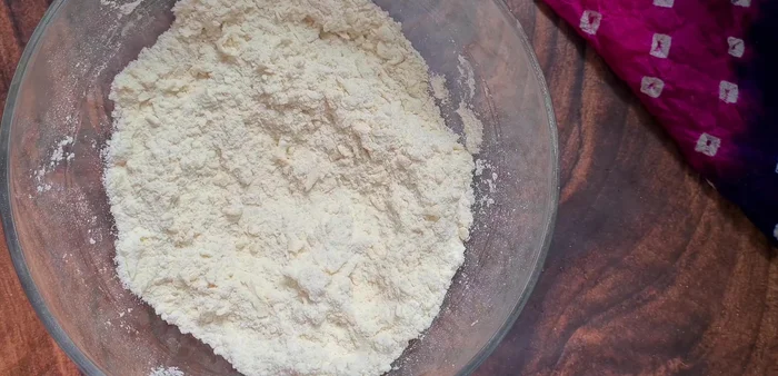 Add curd and mix dry ingredients well. Then gradually add lukewarm milk to form a slightly wet, smooth dough.