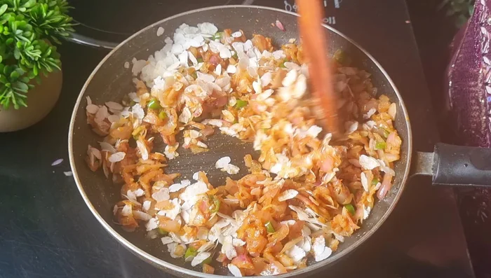 Add poha in two additions, mixing well after each addition. Cook for 1-1.5 minutes until the moisture is absorbed.