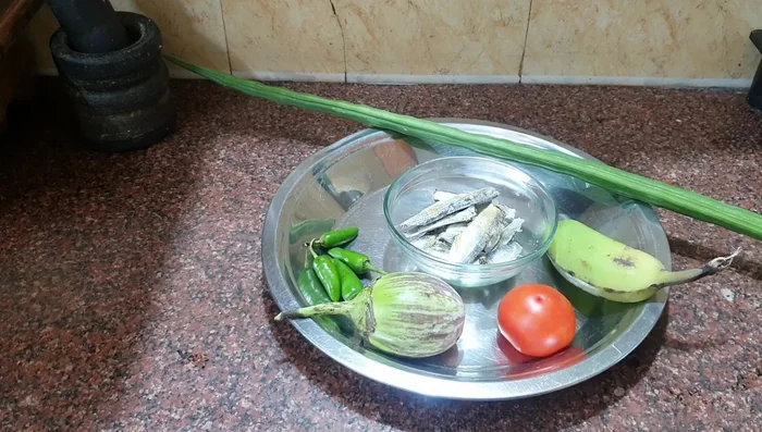 Clean and prepare the vegetables (brinjal, tomato, banana, drumstick, chili).