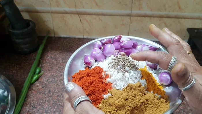 Grind a spice paste with coconut, cumin, onions, turmeric powder, and coriander powder.