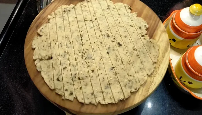 Using a pizza cutter, cut the roti into a square shape, removing any excess dough.
