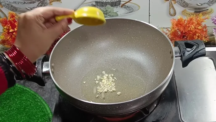 In a separate pan, heat oil. Add chopped garlic and fry until golden.