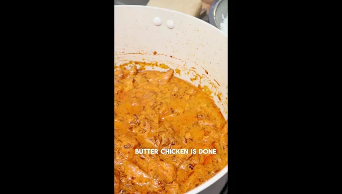 Pour the butter chicken mixture over the rice.