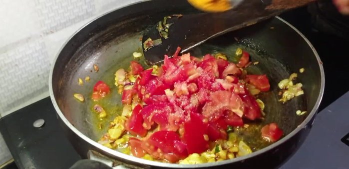 Add finely chopped tomatoes, salt, turmeric powder, chili powder, and garlic paste. Add a little water and cook until tomatoes are soft and spices are fragrant.