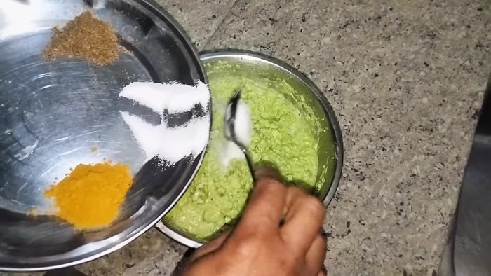 Add salt, turmeric powder, and cumin powder to the ground peas.