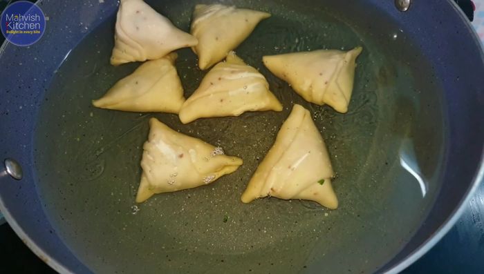 Fry the samosas in medium-heat oil until golden brown.
