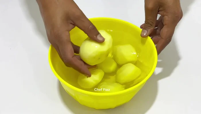 Grate the potatoes using a thick blade grater. Keep them dipped in water to prevent browning. (146.4)