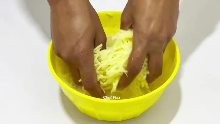 Mash the grated potatoes to remove excess starch and squeeze out excess water. (199.879)