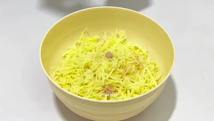 Mix the potatoes with salt, coriander powder, crushed red chili powder, turmeric powder, cumin seeds, gram flour, and corn flour. Do not add water unless necessary as the potatoes will release water. (241.079)
