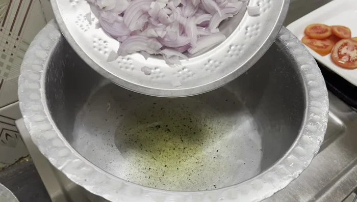 Sauté onions and aromatics: In a vessel, heat ghee and oil. Add sliced onions and lightly sauté until softened. Then add 1 tablespoon of cumin seeds, a cinnamon stick, green cardamoms, black peppercorns and tomato slices; sauté until softened.